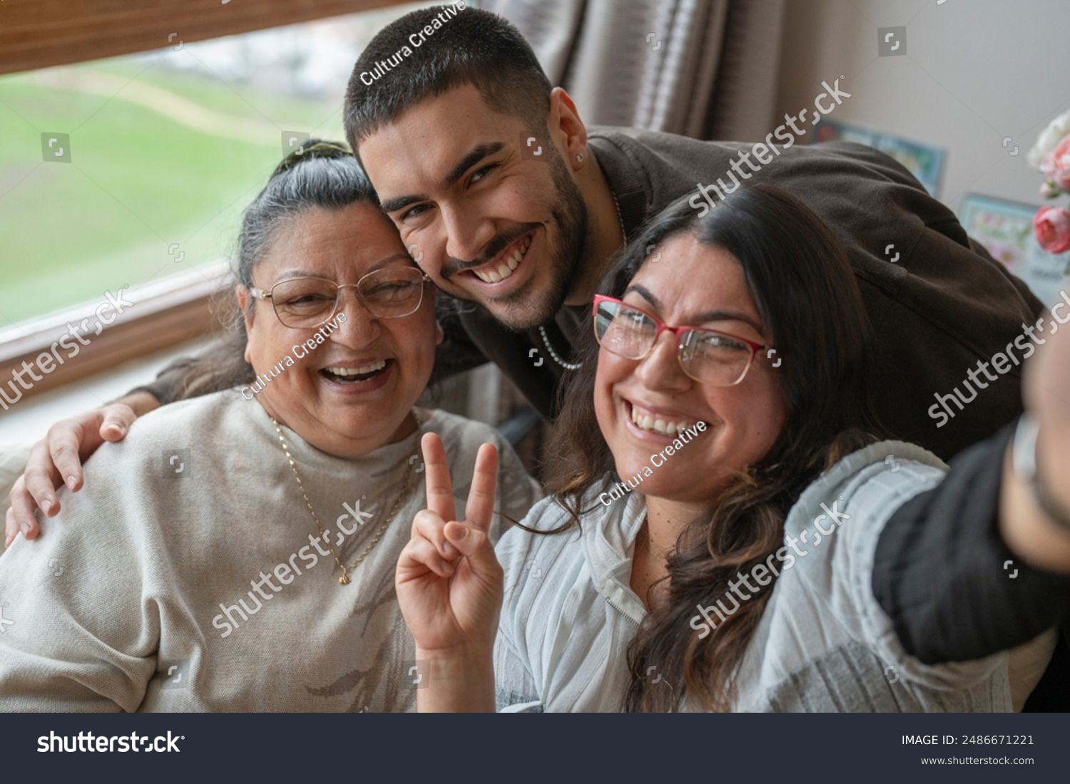 stock-photo-portrait-of-three-generation-family-taking-selfie-at-home-2486671221